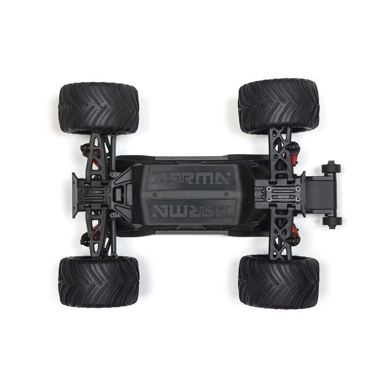 ARRMA 1/16 Quake Grom 4x4 RTR brushed monster truck driving over rocky terrain, showcasing its rugged design and off-road capabilities.