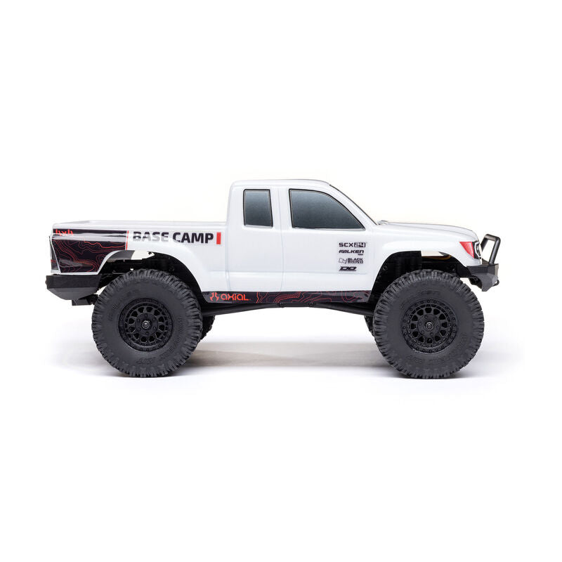 Axial 1/24 SCX24 Base Camp 4X4 RTR brushed rock crawler on rugged terrain with detailed chassis and off-road tires