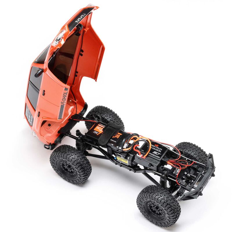 Axial 1/24 SCX24 Toyota 4Runner 4x4 brushed rock crawler RC vehicle on rugged terrain