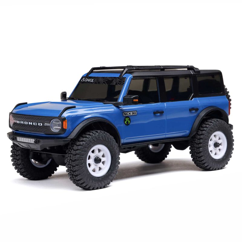 Axial 1/30 scale SCX30 Ford Bronco 4x4 RTR brushed rock crawler on rugged terrain with detailed exterior and off-road tires.