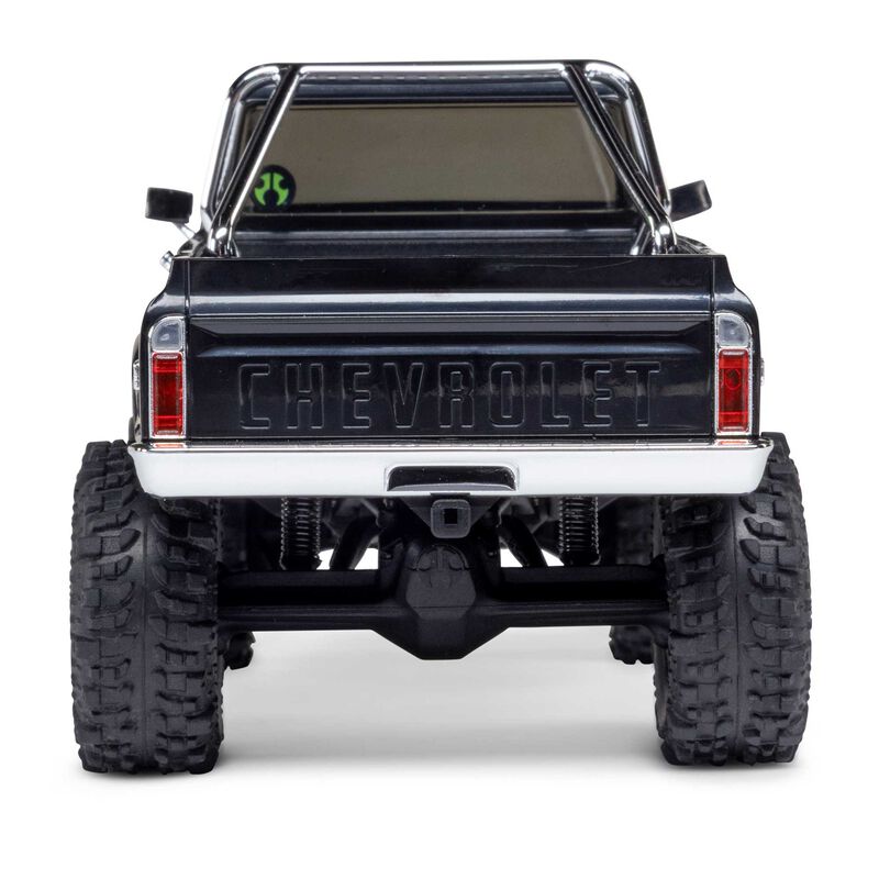 Axial 1/30 scale SCX30 Chevrolet K10 4x4 RTR brushed rock crawler on rugged terrain with detailed body and off-road wheels.