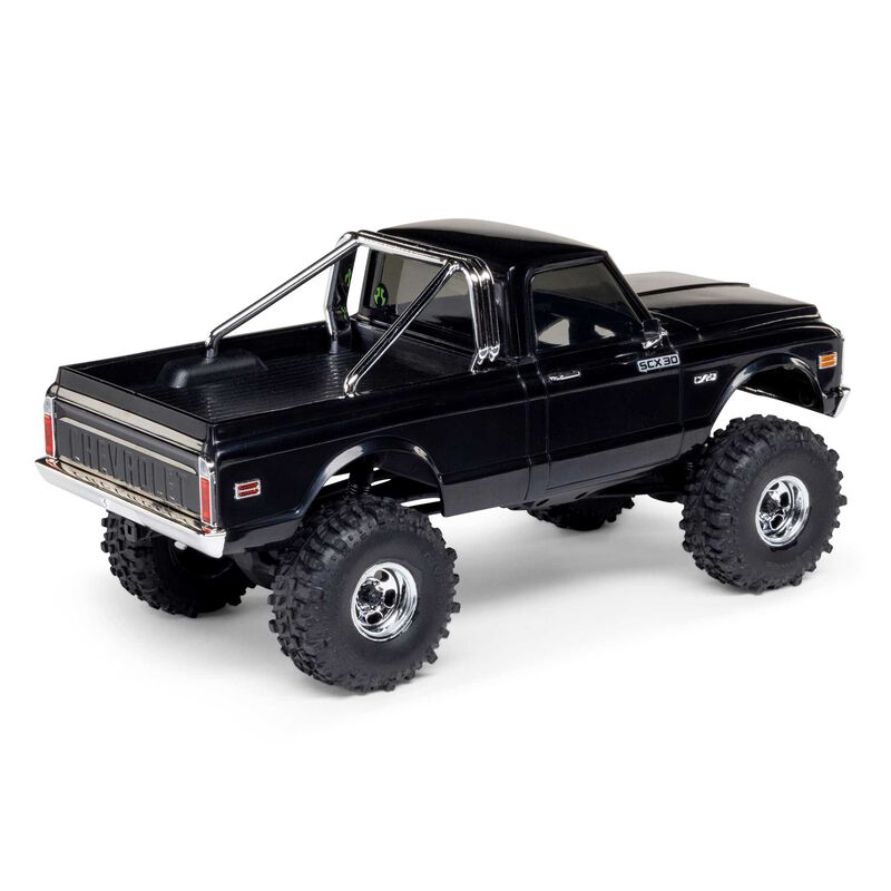 Axial 1/30 scale SCX30 Chevrolet K10 4x4 brushed rock crawler model on rugged terrain.