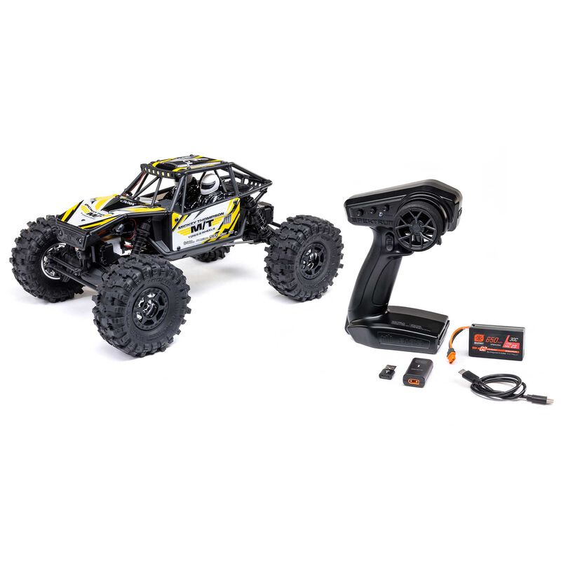 Axial 1/18 Capra 4WS brushed rock crawler with detailed chassis and four-wheel steering in off-road terrain.