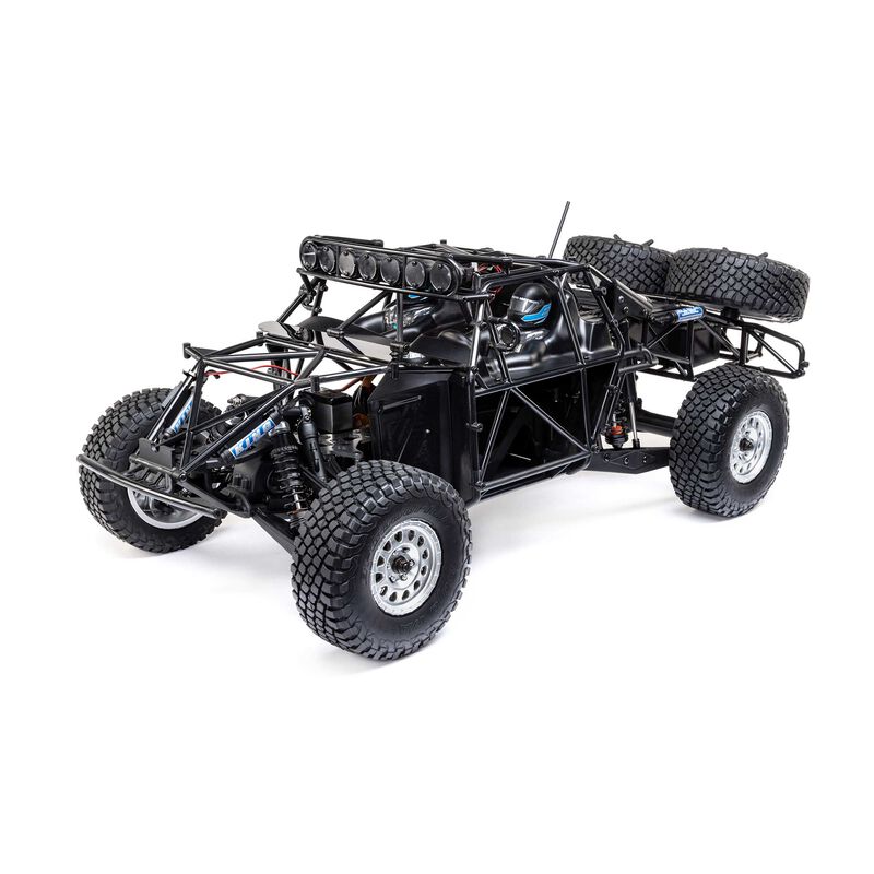 Losi 1/10 Baja Rey 2.0 Ford Raptor RC truck with brushless motor, detailed body, and off-road tires in a rugged outdoor setting