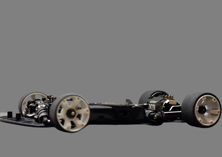 Atomic RC MRX Master Edition linkless 2WD RC car chassis with black and silver components, showcasing the precision engineering and design.