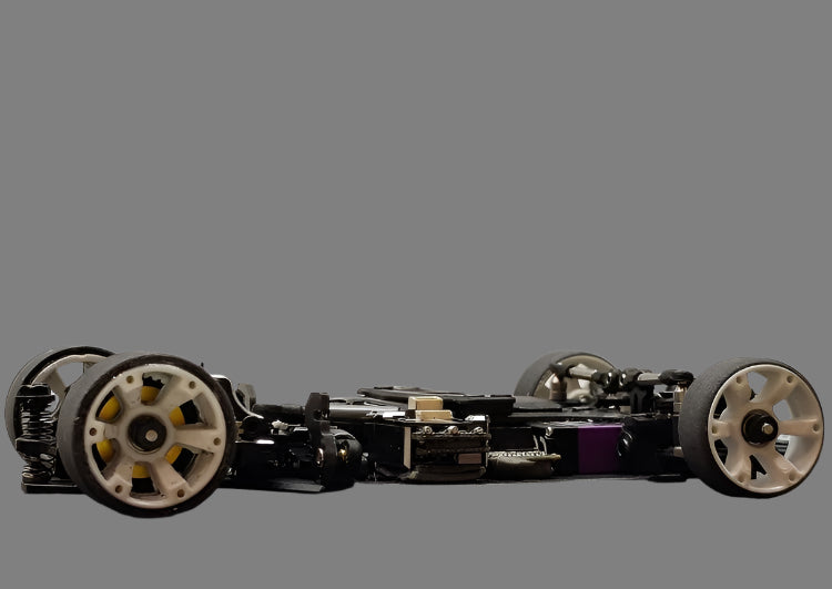 Atomic RC MRX Master Edition Linkless 2WD chassis with detailed metal components and sleek black finish.