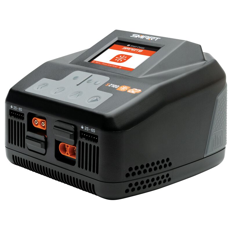 Spektrum S2100 G2 2x100W AC Smart Charger connected to a power outlet, showing digital display and charging cables.