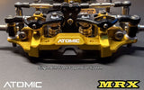 Atomic RC MRX 2WD Pan Car Kit with detailed chassis and components on a workspace.
