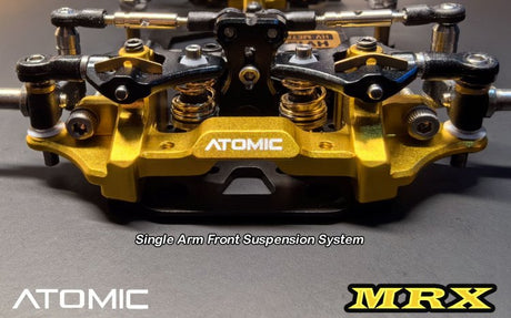 Atomic RC MRX 2WD Pan Car Kit with detailed chassis and components on a workspace.