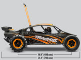 Orange Traxxas Pro Scale Sand Car shown from the side with detailed chassis and large off-road tires, designed for high-performance sand racing.