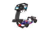 Team Associated F28 Formula RC 1/28 scale 2WD remote control car, showing the detailed orange and black body with racing decals.