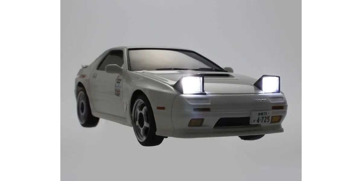 Kyosho First Mini-Z RC Mazda RX-7 FC3S Ryosuke Takahashi car part with detailed design and light accents on a white background.