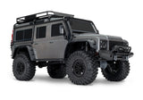 Traxxas TRX-4 Land Rover Defender RC model with silver exterior, front three-quarter view showing detailed rugged design.