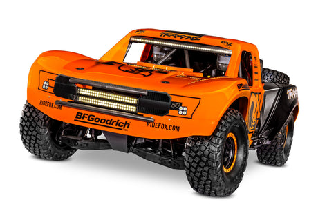 Traxxas Unlimited Desert Racer remote control car with orange body, front view showing sleek design and detailed exterior.