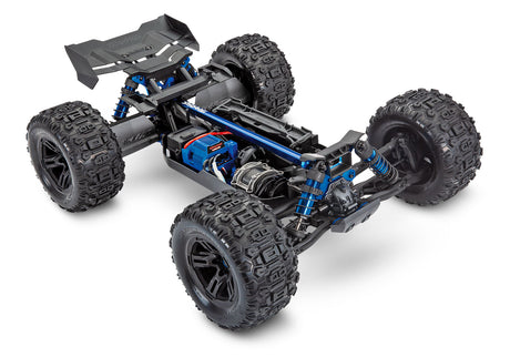Traxxas 1/8 Sledge belted chassis showing front and side view with detailed suspension and rugged off-road tires.