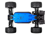 Traxxas 1/8 Sledge belt-driven RC truck chassis bottom view showing suspension and drivetrain components.