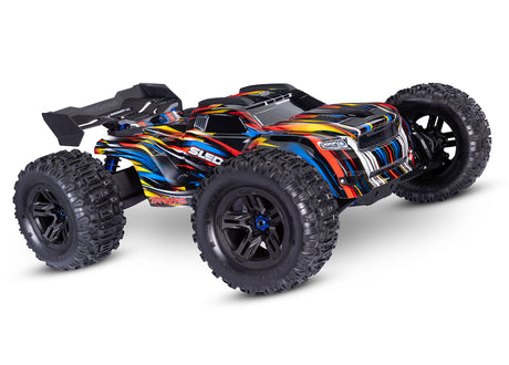 Traxxas 1/8 Sledge belted RC truck with blue body and detailed front view, showcasing rugged design and large tires.