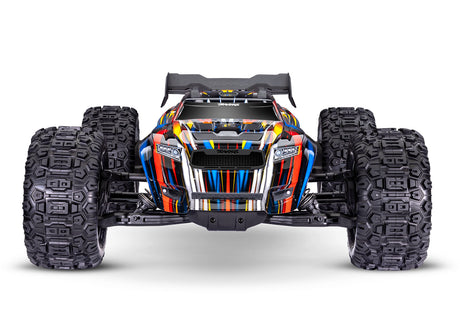 Traxxas 1/8 Sledge belted RC truck with blue body, front view showing rugged tires and detailed chassis.