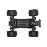ARRMA 1/16 Quake Grom 4x4 RTR brushed monster truck driving over rocky terrain, showcasing its rugged design and off-road capabilities.