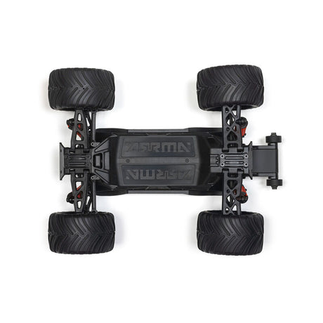 ARRMA 1/16 Quake Grom 4x4 RTR brushed monster truck driving over rocky terrain, showcasing its rugged design and off-road capabilities.