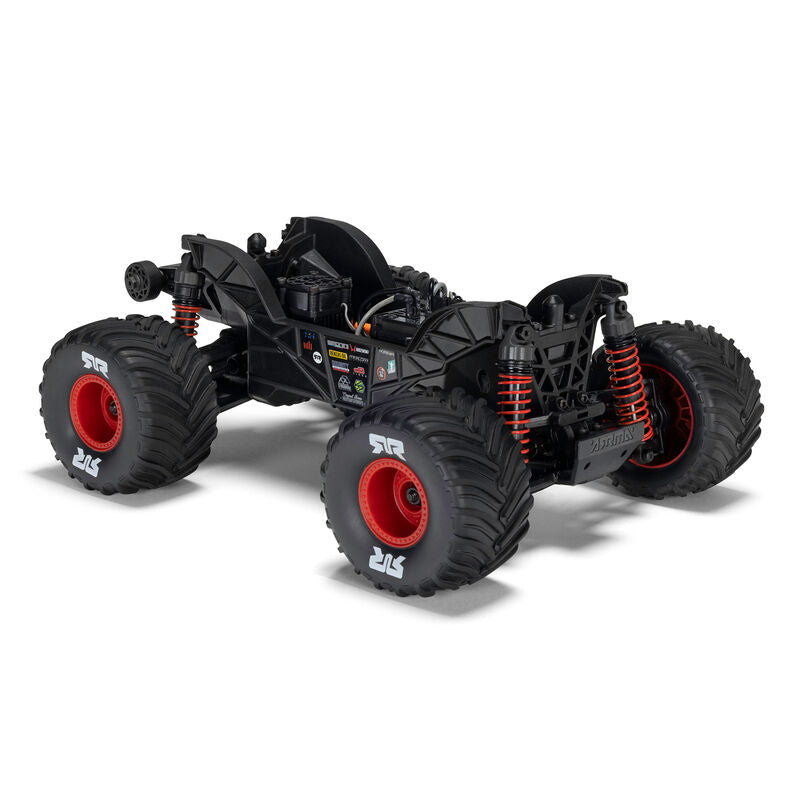 ARRMA 1/16 Quake Grom 4x4 RTR brushed monster truck on rugged terrain, showcasing its compact size and aggressive design.