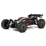 Silver ARRMA 1/14 Typhon GROM 223S DSC 4x4 RTR brushless buggy on off-road track, showcasing detailed design and rugged tires.