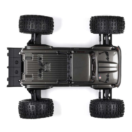 ARRMA Outcast 4X4 4S 1/10th scale 4WD stunt truck shown on rugged terrain, featuring bold design and off-road tires.