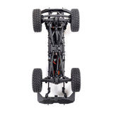 Axial 1/24 SCX24 Base Camp 4X4 RTR brushed rock crawler on rocky terrain with detailed chassis and tires.