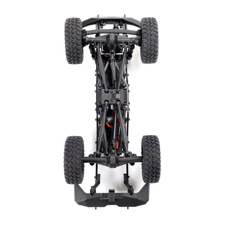Axial 1/24 SCX24 Base Camp 4X4 RTR brushed rock crawler on rocky terrain with detailed chassis and tires.