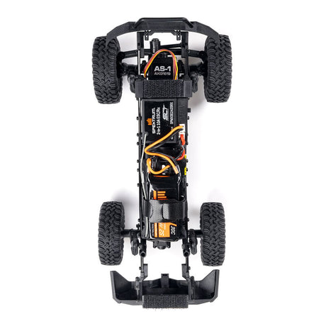 Axial 1/24 SCX24 Base Camp 4X4 RTR brushed rock crawler on rough terrain, showcasing detailed design and off-road features.