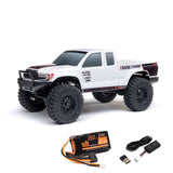 Axial 1/24 SCX24 Base Camp 4x4 RTR brushed rock crawler on rugged terrain with detailed chassis and tires.