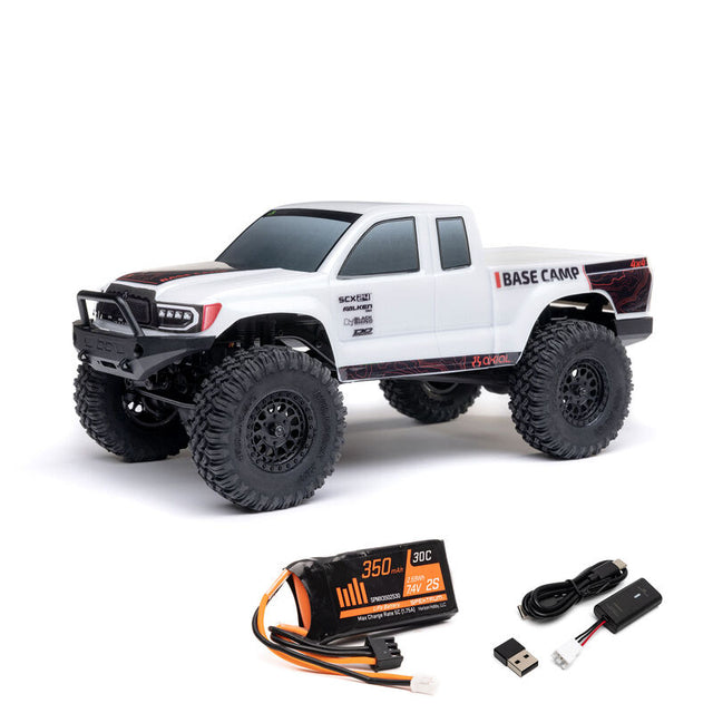 Axial 1/24 SCX24 Base Camp 4x4 RTR brushed rock crawler on rugged terrain with detailed chassis and tires.