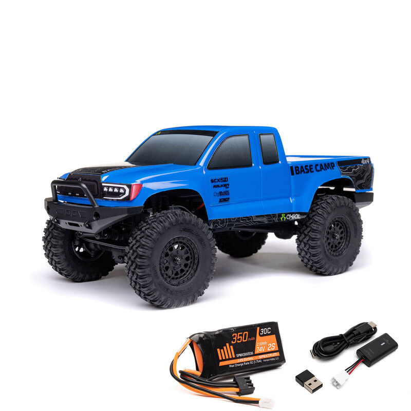 Axial 1/24 SCX24 Base Camp 4x4 RTR brushed rock crawler on rugged terrain with detailed chassis and off-road tires.