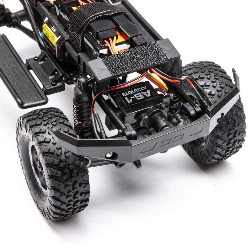 Axial 1/24 SCX24 Lexus GX 470 4x4 RTR brushed rock crawler on rough terrain, showcasing detailed exterior and rugged tires.