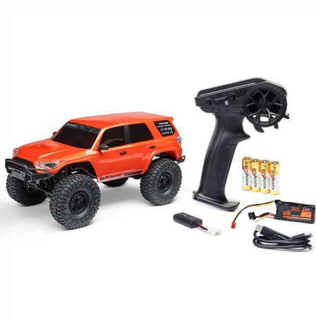 Axial 1/24 SCX24 Toyota 4Runner 4x4 RTR brushed rock crawler on rugged terrain with detailed body and off-road tires.
