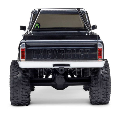 Axial 1/30 scale SCX30 Chevrolet K10 4x4 RTR brushed rock crawler on rugged terrain with detailed body and off-road wheels.