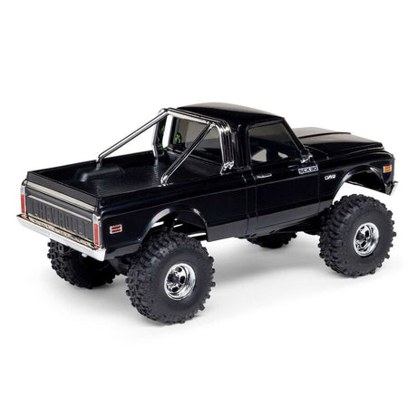 Axial 1/30 scale SCX30 Chevrolet K10 4x4 brushed rock crawler model on rugged terrain.