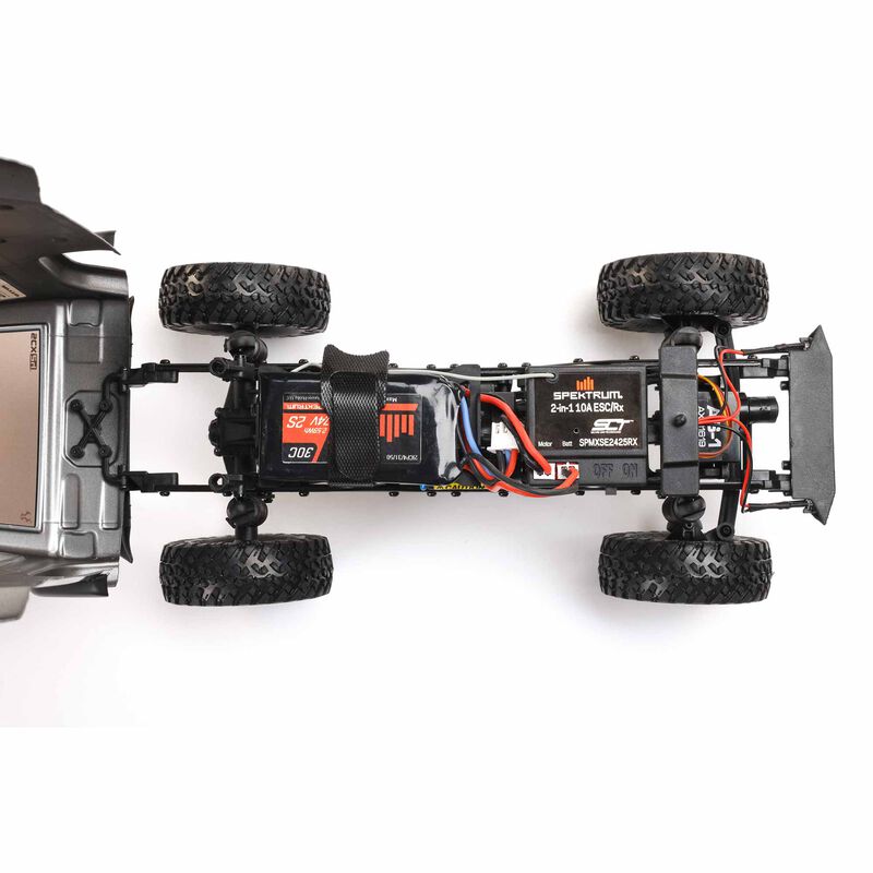 Axial 1/24 scale Jeep Wrangler JLU CRC 4x4 brushed rock crawler on rugged terrain, showcasing detailed off-road vehicle design.