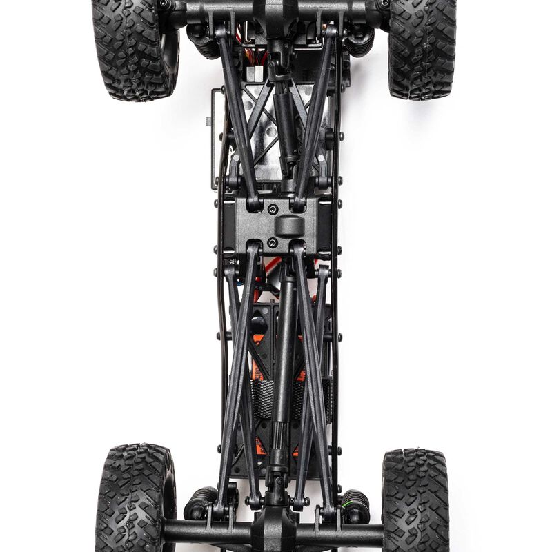 Axial 1/24 SCX24 Jeep JT Gladiator 4x4 RTR brushed rock crawler on rough terrain with detailed exterior and rugged tires.
