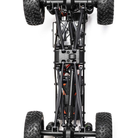 Axial 1/24 SCX24 Jeep JT Gladiator 4x4 RTR brushed rock crawler on rough terrain with detailed exterior and rugged tires.