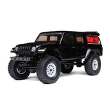 Axial 1/24 SCX24 Jeep JT Gladiator 4X4 RTR brushed rock crawler on rough terrain with detailed exterior and suspension system.