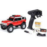 Axial 1/24 SCX24 Ford Bronco 4x4 RTR brushed rock crawler vehicle on rough terrain.