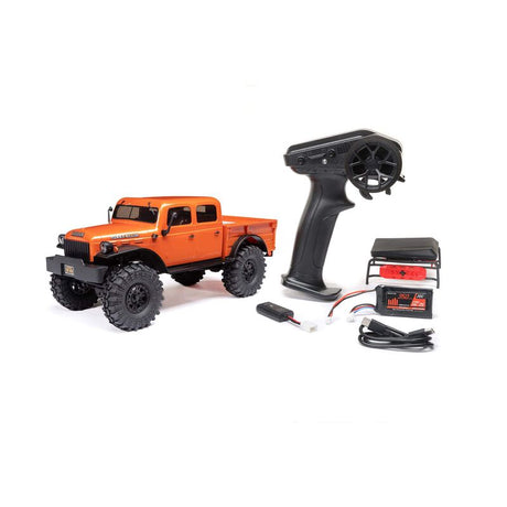 Axial 1/24 SCX24 Dodge Power Wagon 4x4 RTR brushed rock crawler on rough terrain with detailed truck body and rugged tires.