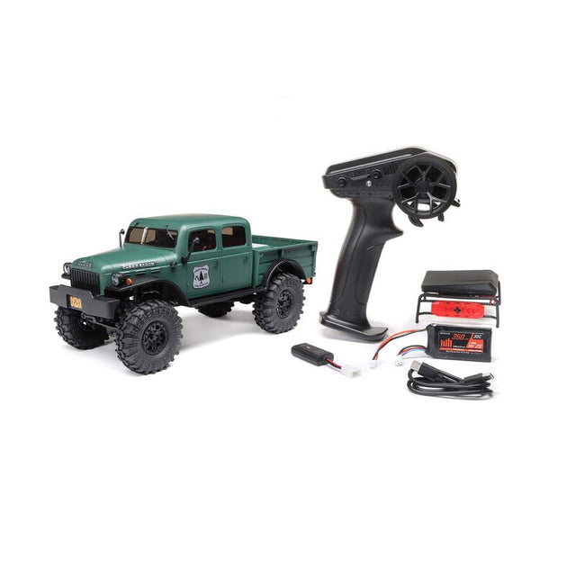 Axial 1/24 SCX24 Dodge Power Wagon 4X4 RTR brushed rock crawler on rough terrain with detailed exterior and rugged tires.