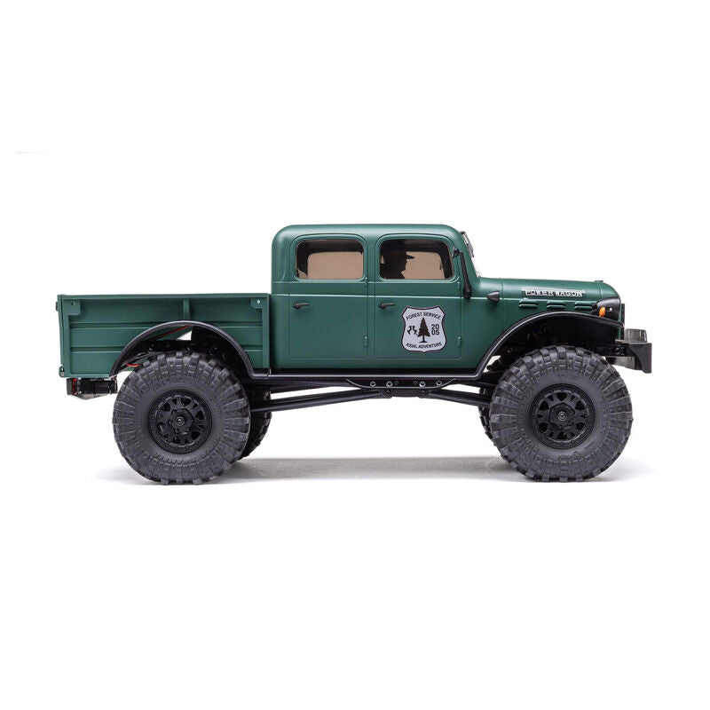 Axial 1/24 SCX24 Dodge Power Wagon 4x4 RTR brushed rock crawler on rugged terrain with detailed exterior and off-road tires.