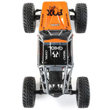 Gray and orange Axial 1/18 UTB18 Capra 4WD RTR trail buggy on rugged terrain, showcasing its compact off-road design.