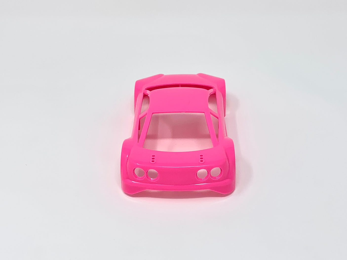 Jomurema GT01 car body set in vibrant neon pink, displayed on a sleek vehicle with detailed design elements.