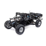 Losi 1/10 Baja Rey 2.0 Ford Raptor RC truck with brushless motor, detailed body, and off-road tires in a rugged outdoor setting