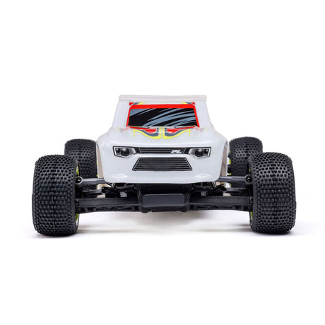 Losi Micro-T 2WD 1/28 scale truggy RC car with detailed body and off-road tires on a race track.
