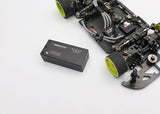 Reflex Racing RRE012 340mAh 7.6V LiHV hardcase RC car lipo battery lying on a surface with cables and tools nearby.
